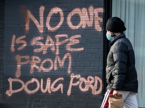 Graffiti stating that "No One Is Safe From Doug Ford" is seen on Toronto's Dundas Street West on April 21, 2021.