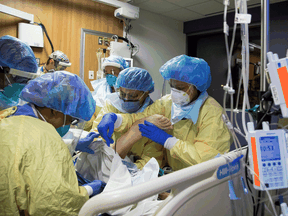 A respiratory therapist and six nurses with a COVID-19 patient inside the intensive care unit of Humber River Hospital in Toronto, April 19, 2021.
