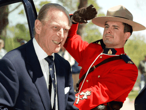 An RCMP officer salutes as Prince Philip arrives to join Queen Elizabeth II for a luncheon Friday, May 20, 2005 in Regina.