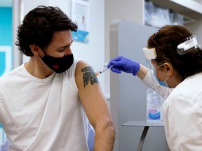 Prime Minister Justin Trudeau is inoculated with AstraZeneca's COVID-19 vaccine at a pharmacy in Ottawa on April 23, 2021. A reader blames Trudeau for the slow vaccine rollout in Canada.