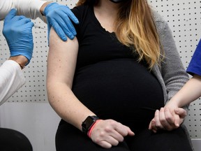 A pregnant woman receives a vaccine for COVID-19 at Skippack Pharmacy in Schwenksville, Pennsylvania, U.S., February 11, 2021.