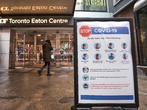 In this file photo people arrive at the entrance to the Toronto Eaton Centre in downtown Toronto, Ontario on November 23, 2020.