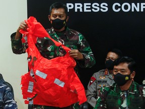 A military personnel holds an escape suit believed to be from the sunken Indonesian Navy KRI Nanggala-402 submarine during a media conference at I Gusti Ngurah Rai Airport in Bali, Indonesia, April 25, 2021.