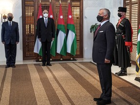 A handout picture released by the Jordanian Royal Palace on March 29, 2021 shows Jordanian King Abdullah II (R) swearing-in the new health minister in the cabinet of PM Bisher al-Khasawneh, in the capital Amman.