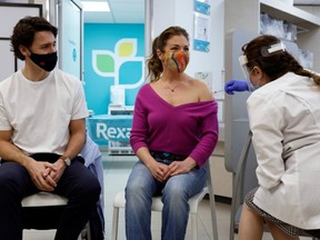 Canada's Prime Minister Justin Trudeau watches as his wife Sophie Gregoire is inoculated with AstraZeneca's vaccine in Ottawa  on April 23, 2021.