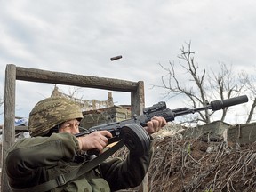 A service member of the Ukrainian armed forces opens fires on an unmanned aerial vehicle at the line of separation from pro-Russian rebels near Donetsk, Ukraine April 11, 2021.