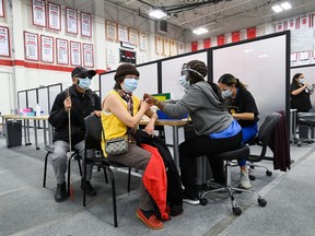 A woman receives her COVID-19 vaccine at the Seneca College mass vaccination site during the COVID-19 pandemic in Toronto on Tuesday, April 6, 2021.