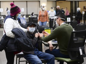 A healthcare worker administers a dose of the Pfizer-BioNTech Covid-19 vaccine at a community vaccination clinic in Ottawa, Ontario, Canada, on Tuesday, March 30, 2021.