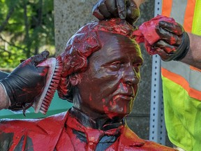 Workers remove red paint from the John A. Macdonald statue in Charlottetown on Friday June 19, 2020.