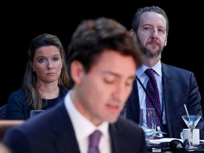 Katie Telford, back left, and Gerald Butts, back right, listen as Prime Minister Justin Trudeau speaks at a First Ministers meeting in Ottawa, in 2016.