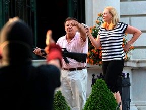 In this June 28, 2020 file photo, armed homeowners Mark and Patricia McCloskey, standing in front their house along Portland Place confront protesters marching to St. Louis Mayor Lyda Krewson's house in the Central West End of St. Louis.