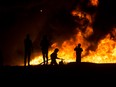 An Israeli firefighter battles a field fire after a rocket launched from the Gaza Strip struck in Ramla, Israel, on May 13.