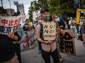 A protester holds a placard saying during a protest against the Tokyo Olympics on May 9, 2021 in Tokyo.