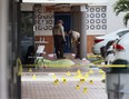 Miami-Dade police investigate near shell case evidence markers on the ground where a mass shooting took place outside of a banquet hall on May 30, 2021 in Hialeah, Florida.