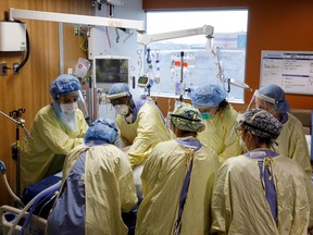 Healthcare workers  turn a patient suffering from coronavirus disease out of prone position at Humber River Hospital's ICU, in Toronto on April 28