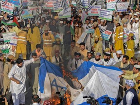 People torch an Israeli flag during an anti-Israel protest in Peshawar, Pakistan, on May 21.