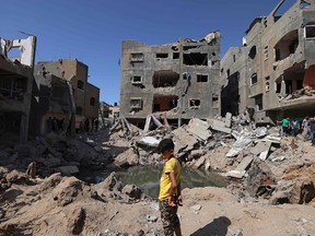 A Palestinian child stands amidst the rubble of buildings, destroyed by Israeli strikes, in Beit Hanun in the northern Gaza Strip on May 21, 2021.