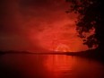 This general view taken on May 22, 2021 from Tchegera Island, outsoide Goma on the lake Kivu, in the East of the Democratic Republic of Congo, shows flame spewing from the Nyiragongo volcano.