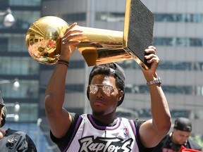 Raptors guard Kyle Lowry shows off the Larry O'Brien trophy to fans during a parade through downtown Toronto to celebrate their NBA title.