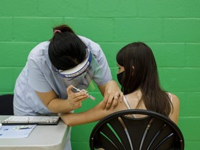 An adolescent receives a dose of the Pfizer-BioNTech COVID-19 vaccine at a clinic in Toronto on Wednesday, May 19, 2021.