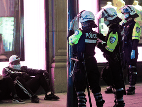 Police issue tickets to people in Montreal on April 12, 2021 for breaking an 8 p.m. curfew imposed by the Quebec government to help curb the spread of COVID-19.