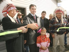 Then-Indian affairs minister Jim Prentice, centre, holds a ribbon-cutting ceremony for the Eden Valley water treatment plant, in Eden Valley, Alta., in 2006.