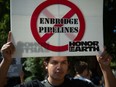 Anti-pipeline activists protest against Enbridge in a file photo from Aug. 25, 2015, in Washington, D.C. Even if Canada wins the battle to keep the Enbridge Line 5 pipeline open, it is losing the war against the anti-Canadian oil movement, writes Ted Morton.