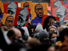 People hold placards with paintings of George Floyd, Daunte Wright and Philando Castile after the verdict in the trial of former Minneapolis police officer Derek Chauvin, found guilty of the death of George Floyd, in front of Hennepin County Government Center, in Minneapolis, Minnesota, on April 20, 2021.