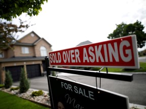 A real estate sign that reads "For Sale" and "Sold Above Asking" stands in front of housing in Vaughan, a suburb in Toronto, Canada, May 24, 2017.