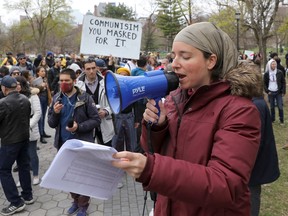 A demonstrator speaks through a megaphone during a protest against new coronavirus disease (COVD-19) restrictions, in Toronto, Canada April 17, 2021.