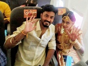 Bride Dakshina and groom Rakesh pose during a flight amid the coronavirus  pandemic, in this still image taken from a video dated May 23, 2021.