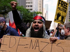 A pro-Palestinian supporter holds a sign comparing the Israeli army, the IDF, to Nazis, in a demonstration in Manhattan on May 18, 2021.