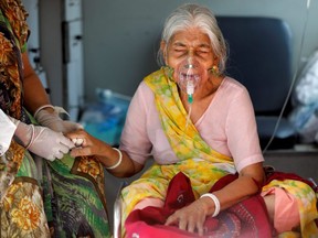 Lilaben Gautambhai Modi, 80, wearing an oxygen mask, sits inside an ambulance as she waits to enter a COVID-19 hospital for treatment, amidst the spread of the coronavirus disease in Ahmedabad, India, on May 5, 2021.