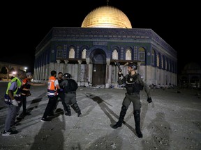 An Israeli policeman scuffles with a Palestinian in front of the Dome of the Rock, in Jerusalem's Old City, on May 7.
