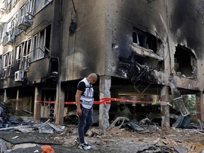 An Israeli man checks the damages after a rocket attack from the Hamas-controlled Gaza Strip, in the central Israeli city of Petah Tikva, on May 13, 2021.