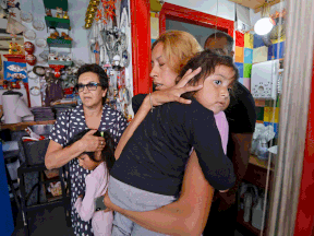 Israelis take cover in a shop  in the country's mediterranean city of Bat Yam, south of Tel Aviv, as a siren rings during an attack of rockets from the Hamas-controlled Gaza Strip, on May 13, 2021.