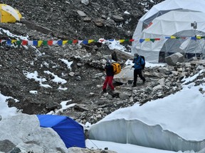 In this picture taken on May 1, 2021 expedition members wearing facemask arrive at Everest base camp, some 140 Km northeast of Kathmandu.