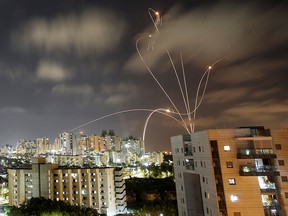 Streaks of light are seen as Israel's Iron Dome anti-missile system intercepts rockets launched from the Gaza Strip towards Israel, as seen from Ashkelon, Israel, on May 12, 2021.
