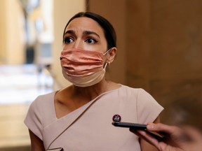 U.S. Representative Alexandria Ocasio-Cortez reacts as she walks past reporters on Capitol Hill in Washington, U.S., May 13, 2021.