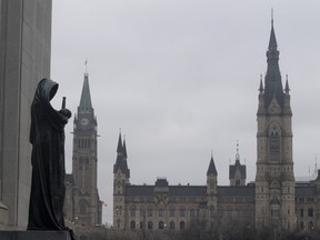 The statue representing justice looks out from the Supreme Court of Canada over the Parliamentary precinct in Ottawa on March 25, 2021.