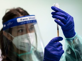 A medical worker prepares a dose of vaccine against the COVID-19 on March 13, 2021 at the local health authority (ASL) offices in Dronero, Maira Valley, near Cuneo, Northwestern Italy, as part of a home vaccination campaign