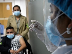 A health worker holds a dose during a vaccination drill before the arrival of the anti COVID-19 vaccines at Patio Bonito Tintal hospital on January 26, 2021 in Bogota, Colombia.