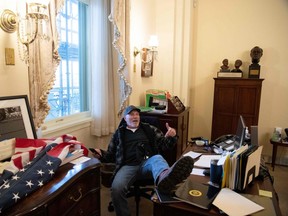Richard Barnett, a supporter of former U.S. President Donald Trump sits inside the office of U.S. Speaker of the House Nancy Pelosi as he protest inside the US Capitol in Washington, DC, January 6, 2021.