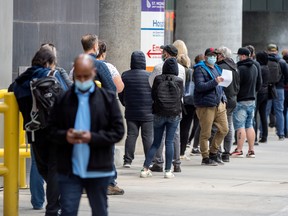People line up outside of Toronto’s St. Michael’s Hospital to receive the COVID-19 vaccine, on April 12.