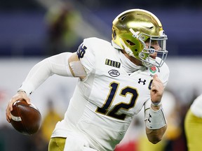 Notre Dame quarterback Ian Book scrambles against the defence of the Alabama Crimson Tide during the 2021 College Football Playoff Semifinal Game at the Rose Bowl Game on Jan. 1, 2021, in Arlington, Texas. North American pro sports leagues have come around to supporting licensed gambling after finally noticing  the ad revenue and fan interest in other countries, writes Colby Cosh.