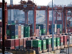 Shipping containers are loaded onto rail cars in Vancouver, British Columbia, on March 21, 2020.