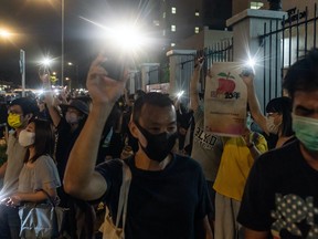 Supporters shine their smartphone lights towards the Apple Daily newspaper offices on June 23, 2021 in Hong Kong, China. Hong Kong’s largest pro-democracy newspaper announced it would be printing its final issue on Thursday after its offices were raided last week over allegations that reports had breached a controversial national security law.