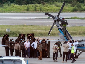 Colombia's President Ivan Duque (L) walks surrounded by bodyguards close to the presidential helicopter at the tarmac of the Camilo Daza International Airport after it was hit by gunfire in Cucuta, Colombia on June 25, 2021.