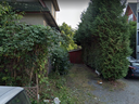 A Google Street View image of 1912 William St., a Vancouver property currently listed for $249,000. The property, which is a 9 foot x 60 foot microlot, consists of the gravel driveway with the shed at the back. 