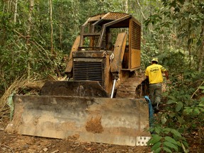 A member of the Chico Mendes Institute for Biodiversity Conservation (ICMBio) walks next to a tractor used for deforestation at the National Forest Bom Futuro in Rio Pardo, Rondonia State, Brazil, September 13, 2019.